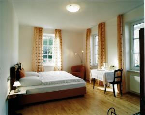 DorsheimGästehaus zum Goldberg的卧室配有床、桌子和窗户。