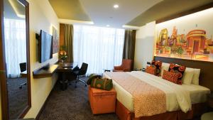 内罗毕Sarova Panafric Hotel的酒店客房配有一张床、一张书桌和一台电视。