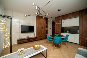 卢布林Apartament Gold - Racławickie 28a的客厅配有桌子和蓝色椅子