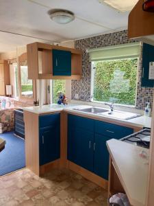 德拉姆纳德罗希特Forest View - Adults Only - Maximum 2 Guests的厨房配有蓝色橱柜、水槽和窗户。