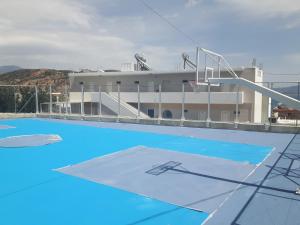 圣加利尼安提戈涅酒店的一个空的游泳池,有一座建筑的背景