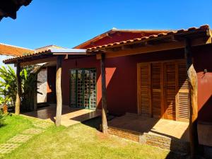 博尼图RANCHO DA PISCINA EM BONITO的红色的房子,设有木门和门廊