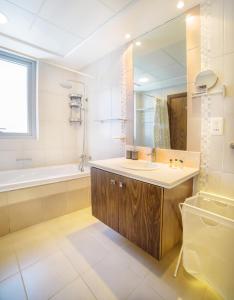 迪拜New Large Apartment with Downtown View的一间带水槽、浴缸和镜子的浴室