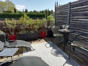 普罗旺斯艾克斯Sweet Home studio Aix en Provence, terrasse, piscine, resto,的庭院配有桌椅和植物