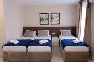 瓦列沃Villa BonnaDea的一间卧室配有两张带蓝白色床单的床