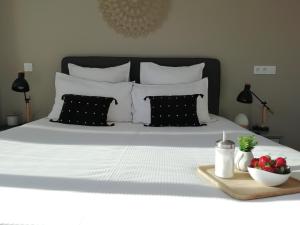 普罗旺斯艾克斯Sweet Home studio Aix en Provence, terrasse, piscine, resto,的一张带黑白枕头的床和一碗草莓