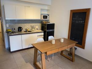 布宜诺斯艾利斯Apartamento nuevo en Congreso- amplio- vista inigualable的厨房配有木桌和黑冰箱。