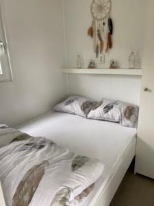 艾默伊登Luxe Chalet Marbella IJmuiden aan Zee的一间卧室配有一张带白色床单和架子的床