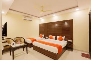 新德里Hotel Citizen New Delhi的酒店客房设有两张床和电视。