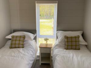 约克Hollicarrs - Newlands的卧室的窗户旁设有两张床