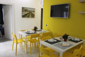 锡拉库扎B&B CaselloA Suites的用餐室配有2张桌子和黄色椅子
