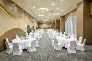 麦加Millennium Makkah Al Naseem的宴会厅配有白色的桌子和白色的椅子