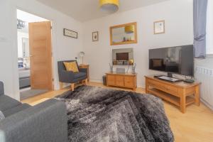 蒂恩格Scalpay@Knock View Apartments, Sleat, Isle of Skye的带沙发和平面电视的客厅