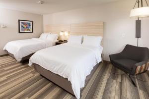 Logansport洛根斯波特智选假日酒店的酒店客房,配有两张床和椅子