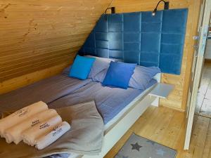 科帕利诺Zacisze Kopalino的小木屋内的一张床铺,配有蓝色枕头