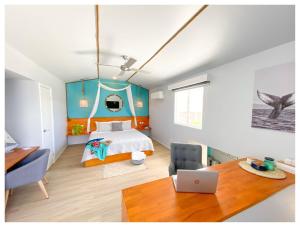拉罗汤加Ocean Escape Resort & Spa的一间卧室配有一张床和一张带笔记本电脑的书桌