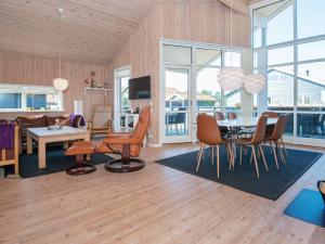 法贾德嘉德Three-Bedroom Holiday home in Ulfborg 23的用餐室以及带桌椅的起居室。