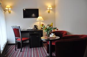 新托梅希尔阿奇姆酒店的酒店客房配有书桌和桌椅