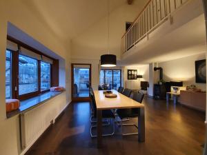 安特特泽Luxuriöses Galerie-Penthouse direkt am Walensee的用餐室以及带桌椅的起居室。
