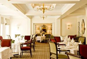 纽布里奇卡德恩酒店的餐厅配有白色的桌椅和吊灯
