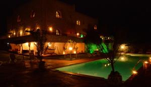 索维拉达尔埃萨达旅馆的一座游泳池,在晚上在建筑物前