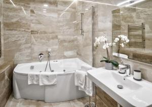 格罗德诺LIRA EuApartments的白色的浴室设有浴缸和水槽。
