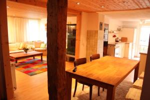 阿尔特施泰滕菲林沃格鲁恩酒店的厨房以及带木桌和椅子的客厅。