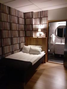 沃尔高达Hotell Greven的一间卧室配有一张带镜子和水槽的床