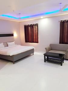 GiriakHotel Abhilasha的一间卧室配有一张床和一张沙发