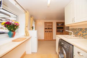 皮特洛赫里Aftonbank的厨房配有洗衣机和烘干机以及窗户。