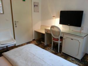 卢加诺科利布瑞酒店的客房设有书桌、电视和床。