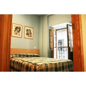 坎加斯德尔纳尔塞亚La Refierta的一间卧室设有一张床、一个窗口和一面镜子