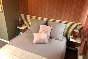 埃塔普勒Gite PIPIOU ETAPLES 2 à 4 Personnes的床上有两张粉红色枕头