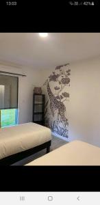 Fresnicourt-le-DolmenBelle vue D'Olhain的一间卧室设有两张床和长颈鹿壁画。