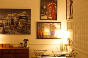 伦敦广场酒店的一间房间,配有一张桌子和一盏灯,墙上挂着照片
