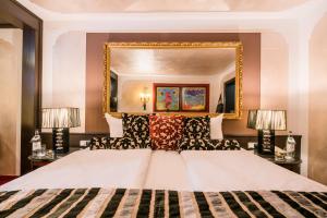 上施陶芬路德维格皇家高尔夫阿尔平康体度假酒店的一间卧室配有一张大床和镜子