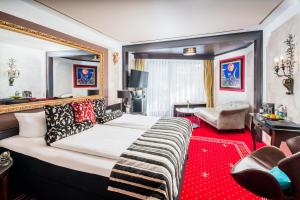 上施陶芬路德维格皇家高尔夫阿尔平康体度假酒店的一间卧室配有一张大床,铺有红地毯