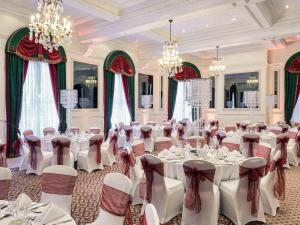 布里斯托莫库尔布里斯托尔格兰德酒店的宴会厅配有白色的桌椅和吊灯