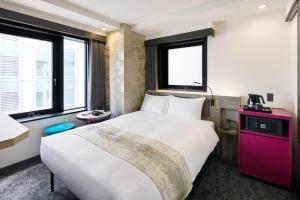 东京the b ginza的酒店客房带大型白色床和窗户。