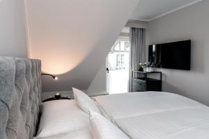 韦斯特兰Jaumann's Südwind Sylt的一间卧室配有一张床和一台平面电视
