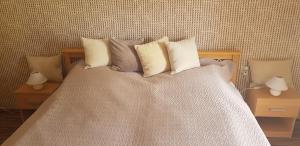尼赖吉哈佐Mimi Apartment的一张带四个枕头的床和两张桌子