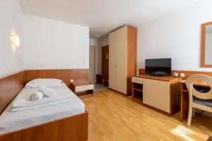 扎达尔波尔图酒店的一间卧室配有一张床和一张书桌及电视