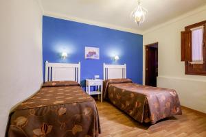 奥苏纳萨尔瓦多布兰科卡瓦略旅舍的一间卧室设有两张床和蓝色的墙壁