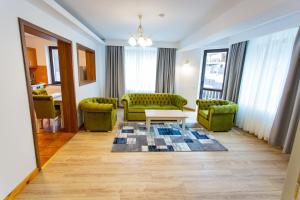 锡纳亚Pension Carmen`s Mansion A的客厅配有两张绿色沙发和一张桌子