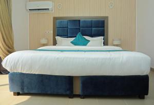 拉各斯Riviera Suites的卧室内的一张带蓝色床头板的大床