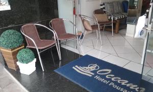 托雷斯HOTEL POUSADA OCEANO的一间设有椅子和标志的餐厅