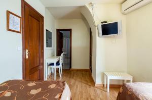 奥苏纳萨尔瓦多布兰科卡瓦略旅舍的客房设有床、书桌和电视。