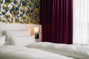 施瓦格明德雷姆斯帕克酒店的一间卧室设有两张床,窗户配有窗帘