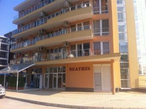 阳光海滩Beatris Family Hotel的一座黄色的大建筑,字眼有用