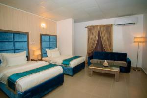 拉各斯Riviera Suites的酒店客房,设有两张床和一张沙发